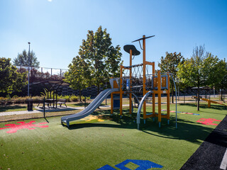 Obraz premium A beautiful children's playground on the parking area near the D1 highway near the town of Považská Bystrica in Slovakia. On the playground, children can have fun on climbing frames, swings and other.