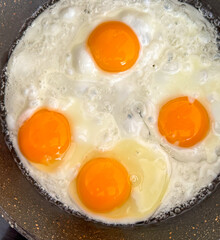 A pan of eggs is cooking on a stove