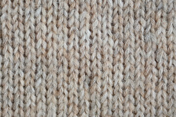The texture of fabric thick beige sweater close-up. Knitted texture background
