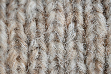 The texture of fabric thick beige sweater close-up. Knitted texture background