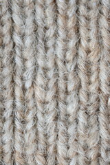 The texture of fabric thick beige sweater close-up. Knitted texture background