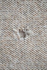 hole in a brown pastel jumper, hole in a tan woollen jumper,	knitted sweater beige texture