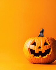 Halloween pumpkin decoration with carved Jack o lantern on orange backdrop and ample copy space