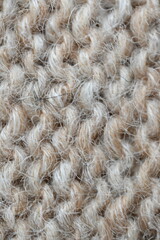 The texture of fabric thick beige sweater close-up. Knitted texture background