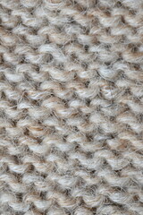 The texture of fabric thick beige sweater close-up. Knitted texture background