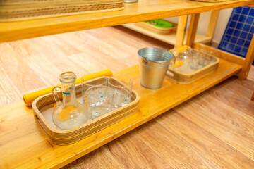 Wooden Montessori shelf with glassware and pitcher