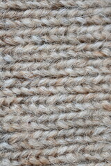 The texture of fabric thick beige sweater close-up. Knitted texture background