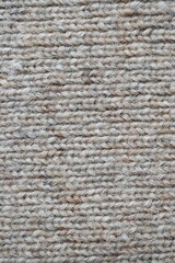 The texture of fabric thick beige sweater close-up. Knitted texture background