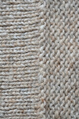 The texture of fabric thick beige sweater close-up. Knitted texture background