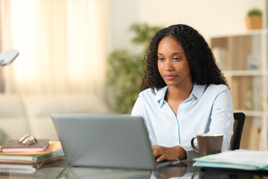 Serious black businesswoman working online at home