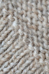  texture of knitted light brown sweater, close-up texture of beige knitted fabric, macro texture of tan knitted woolen clothes   