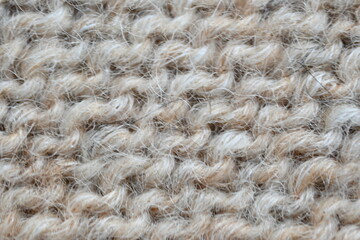  texture of knitted light brown sweater, close-up texture of beige knitted fabric, macro texture of tan knitted woolen clothes   