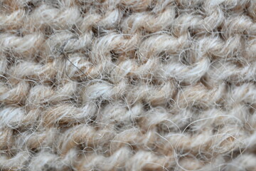  texture of knitted light brown sweater, close-up texture of beige knitted fabric, macro texture of tan knitted woolen clothes   