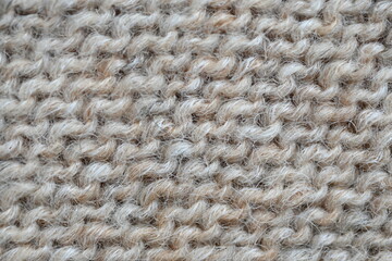  texture of knitted light brown sweater, close-up texture of beige knitted fabric, macro texture of tan knitted woolen clothes   
