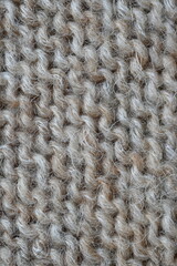  texture of knitted light brown sweater, close-up texture of beige knitted fabric, macro texture of tan knitted woolen clothes   