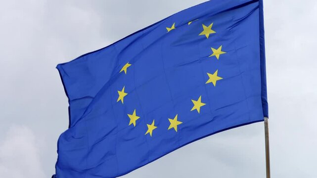 The European Union flag waves gracefully in the wind, symbolizing unity and cooperation among European nations