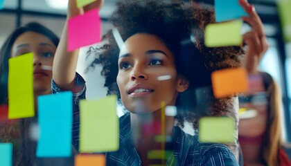Woman with Afro Putting Up Sticky Notes on Glass Wall