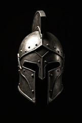 Fototapeta premium The iconic Spartan helmet stands proudly, showcasing its formidable design and intricate features in a dramatic light, evoking a sense of ancient valor and history