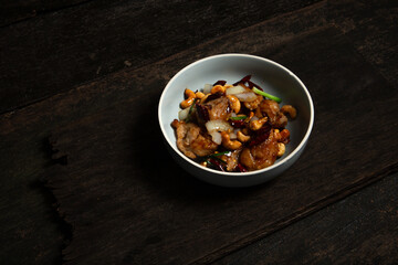 Gai Pad Med Mamuang, Thai Cashew Chicken in gray bowl on old wooden table