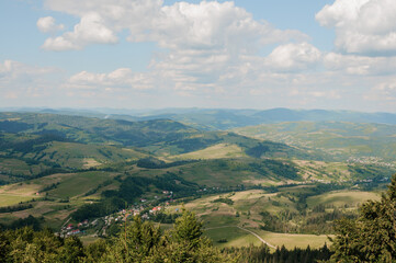 Fototapeta premium Serene Panoramic Landscape of Rolling Hills Under a Blue Sky