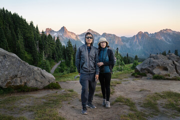 Obraz premium Couple posing for photos at Paradise at sunset. Mount Rainier National Park. Washington State. USA.