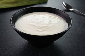 Yogurt served in a black bowl.