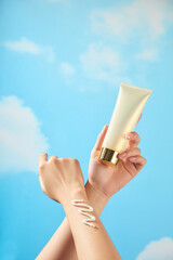 The model hands rub together, squeezing a zigzag cream streak and holding a beige tube cream mockup...