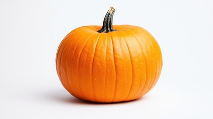 Obraz premium Vibrant orange pumpkin on white background symbolizing abundance and health