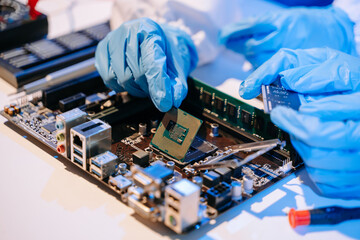 The technician is putting the CPU on the socket of the computer motherboard. electronic engineering