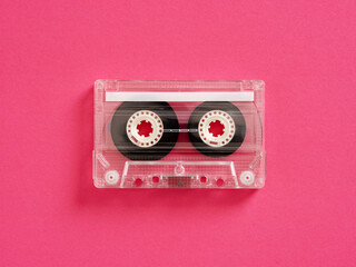 Audio cassette tape lying on pink background