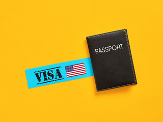 Black passport lying near usa visa on yellow background