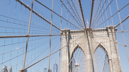 Obraz premium Brooklyn Bridge to Manhattan downtown, cables and blue sky. New York City iconic symbol, USA travel destination. Architecture of United States of America, tourist landmark. Famous cable-stayed bridge.