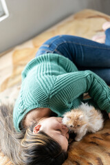 Young latina woman with baby cat in bedroom