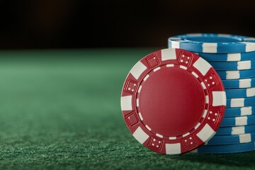 Naklejka premium Stacks of casino chips on green felt table