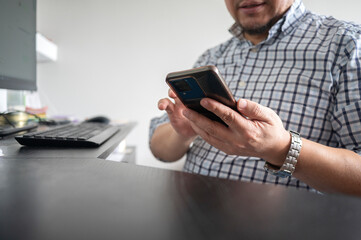 Close up of man hands using smartphone at work