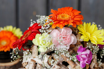 Florist at work: woman shows how to make table decoration with flowers and birch ball.