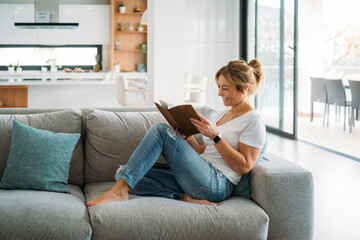 Blonde woman reading on sofa