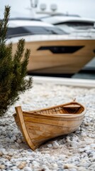 Wooden boat on pebble beach with yachts in the background
