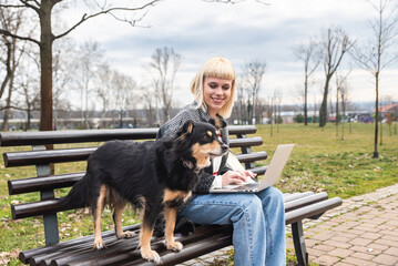 Young woman pet owner spending quality time with her adopted rescued dog outdoor walking and...