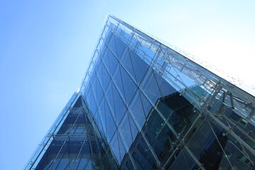 Perspective view from below to corner of office building made of toned glass and steel...
