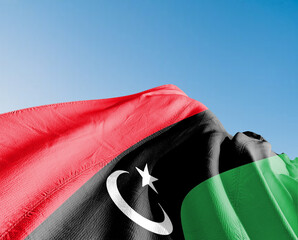 Libya national flag cloth fabric waving on beautiful window sky Background.