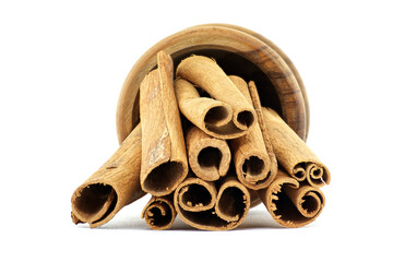 Closeup of cinnamon sticks in wooden bowl isolated on white background