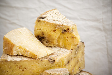 aged cheese wedges with rustic texture on white showcasing artisanal craftsmanship and rich flavor