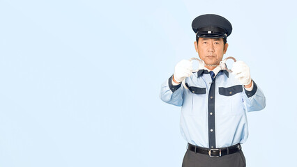 手錠を見せる男性警察官