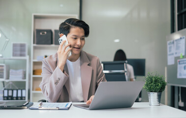 Male businessman talk mobile phones and working on laptop computers, online business, work from home, teleworking concept.