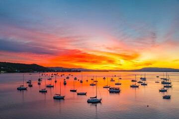 Naklejka premium Aerial sunrise waterscape with boats and high cloud