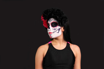 Young Mexican woman made up as Catrina or skull with flower crown to celebrate the Day of the Dead in Mexico