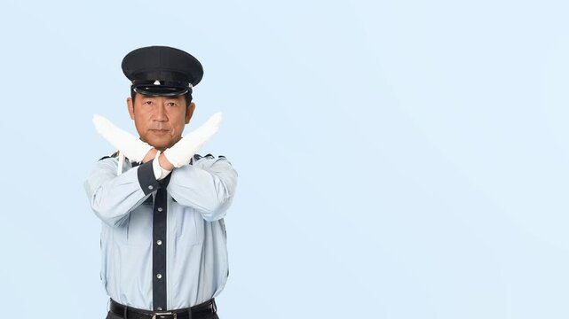 手でバツ印を見せる男性警備員