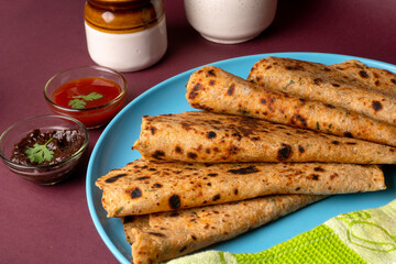Healthy Indian Mooli or Radish paratha or stuffed flatbread with coriander and green chilli chutney on wooden background