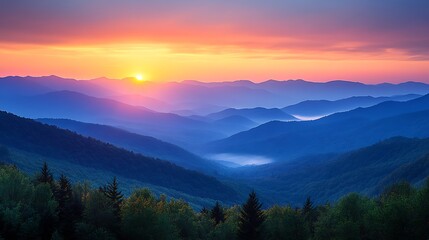 Obraz premium A breathtaking sunrise over a mountain range with a soft haze and fog in the valleys. 